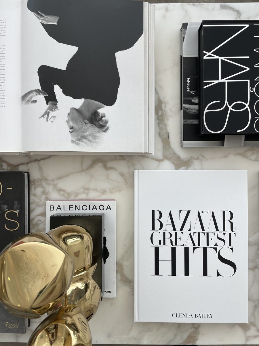 Coffee table flat lay with fashion books and gold sculpture