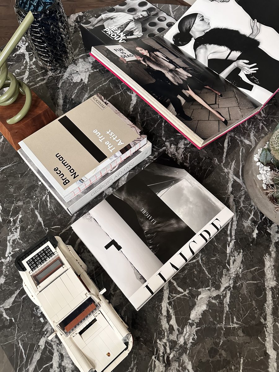 Dark marble coffee table with stacked books and Lego Porsche